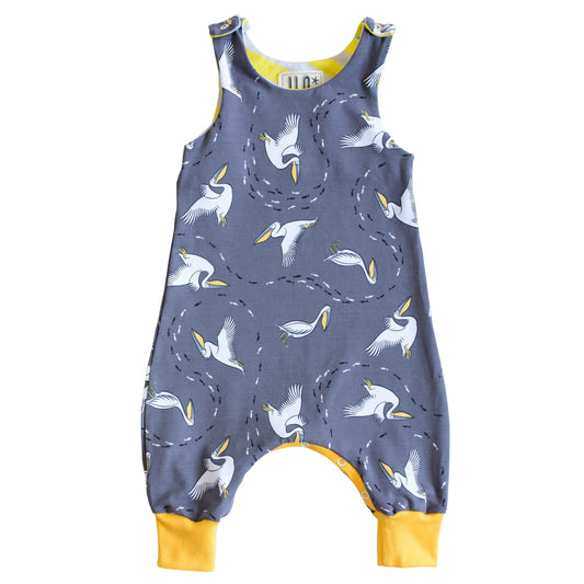 Pelicans on grey organic romper with yellow contrasting cuffs, little black and white fishes swim all through it.