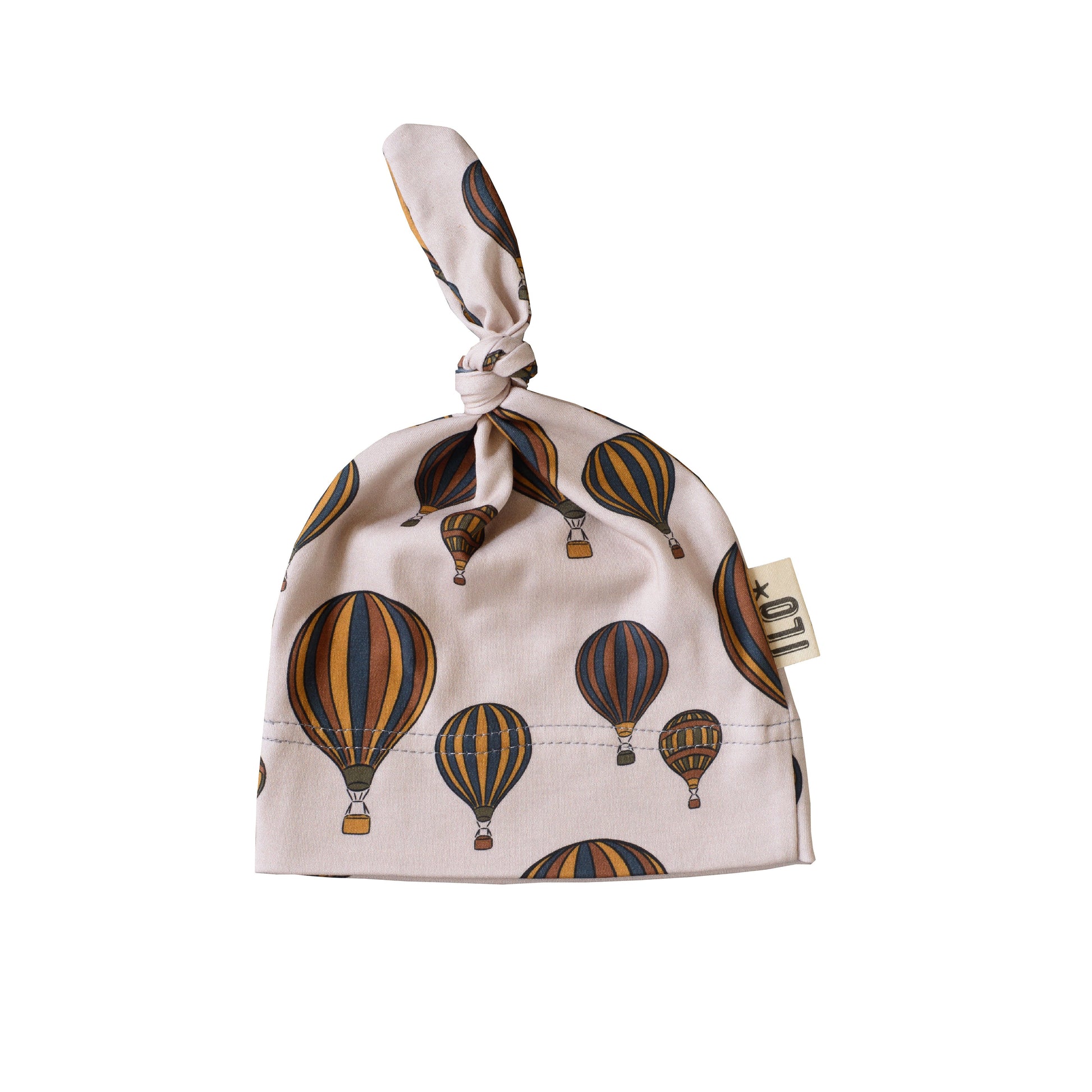 Hot Air balloons browns and blues and sand background knot hat made in Bristol, UK with 100% organic cototn interlock.